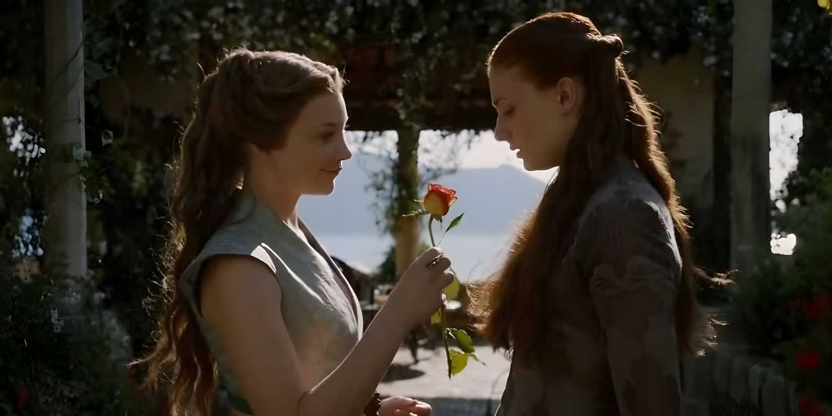 Natalie Dormer holds a rose in front of Sophie Turner in Game of Thrones.