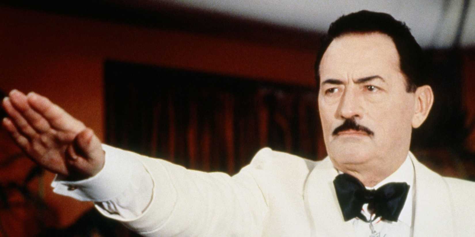 Gregory Peck in a white tux and black bow tie saluting with his arm straight out in The Boys From Brazil.