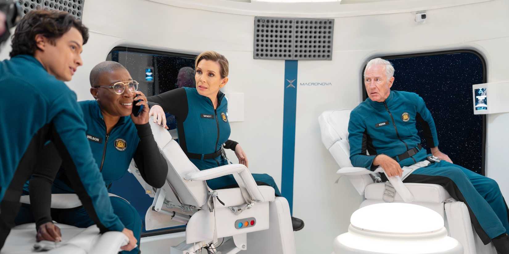 Hen Wilson makes a phone call from a spaceship, surrounded by her fellow passengers, in Season 9 of 9-1-1.