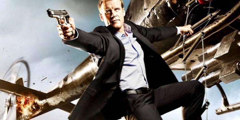 Christopher Chance (Mark Valley) aims his gun while hanging from a helicopter on 