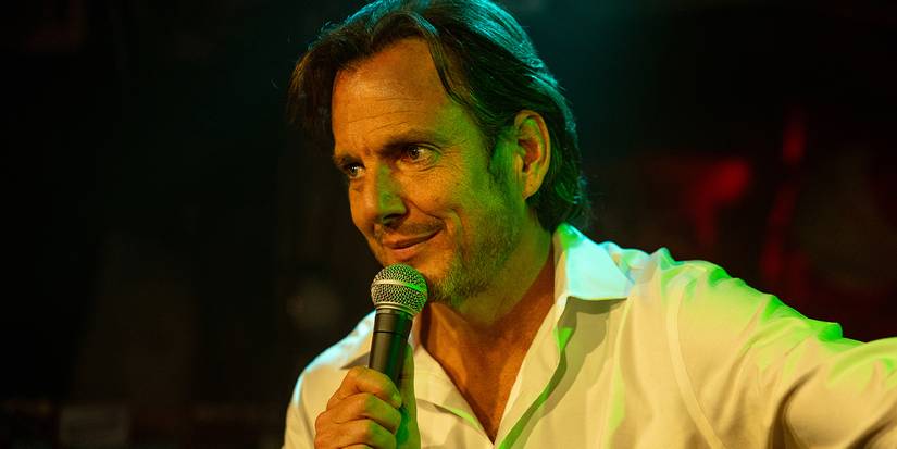 Will Arnett as Alex Novak, holding a microphone in Is This Thing On?