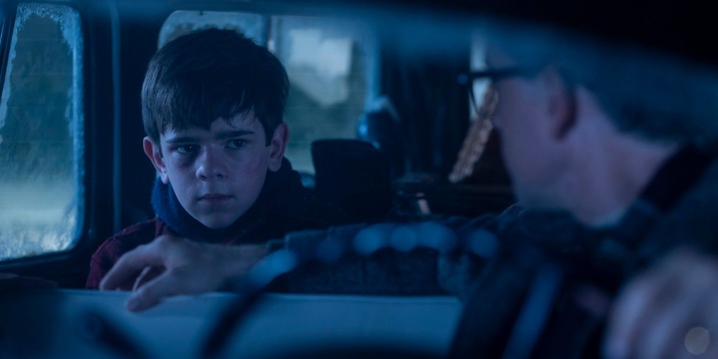 Miles Ekhardt as Matty sitting in a car with a family that picked him up hitchhiking in IT: Welcome to Derry