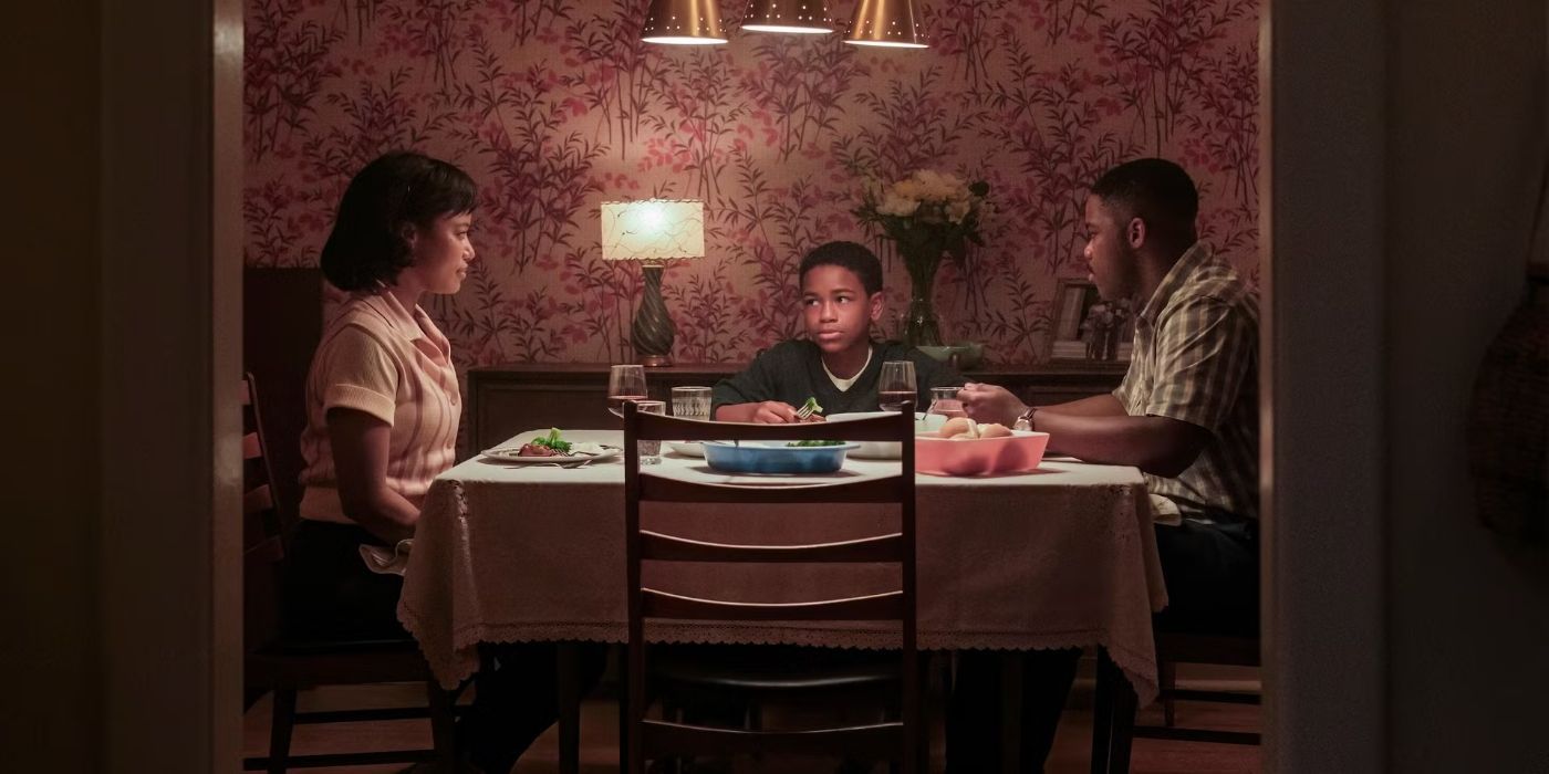 A family of three (mother, father, son) sit around a table at dinner in IT Welcome to Derry
