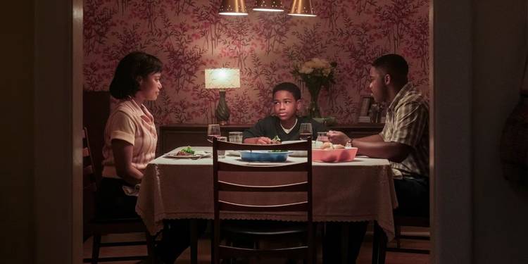 A family of three (mother, father, son) sit around a table at dinner in IT Welcome to Derry
