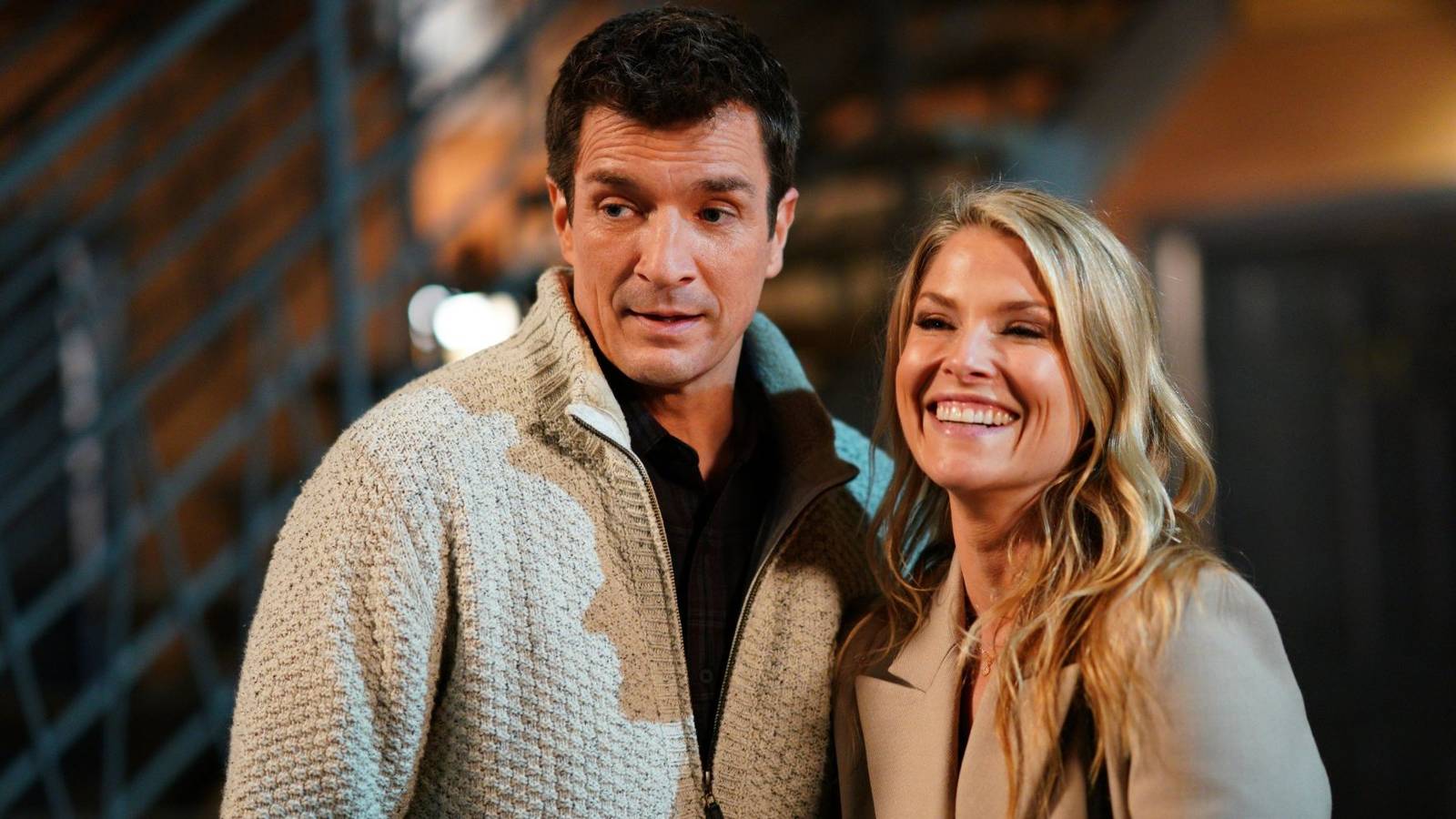 Ali Larter as Grace smiling next to Nathan Fillion as John in The Rookie.