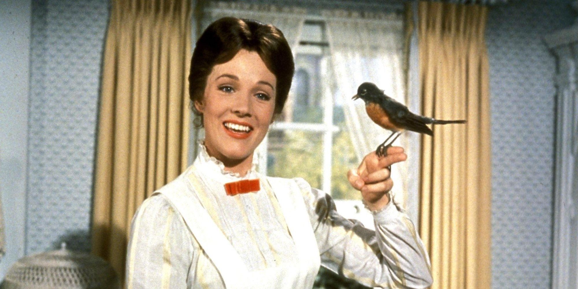 Julie Andrews as Mary Poppins smiles while a bird sits on her finger in Mary Poppins