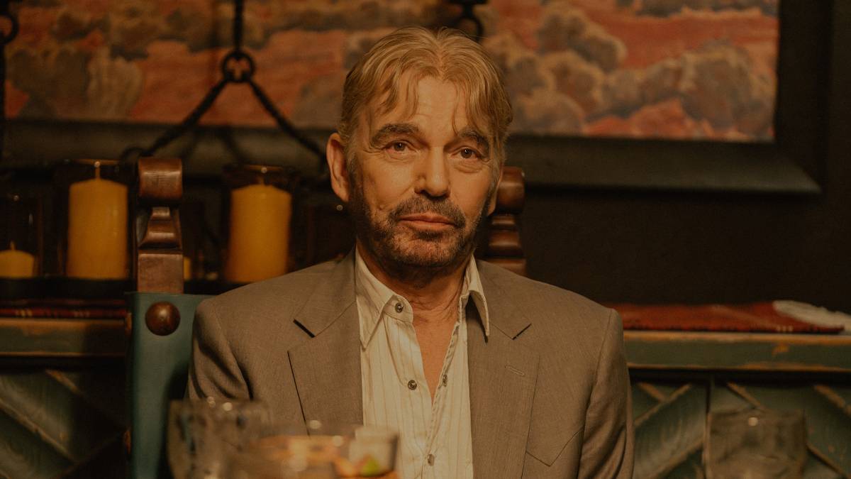 Billy Bob Thornton as Tommy Norris sitting at a table in Landman