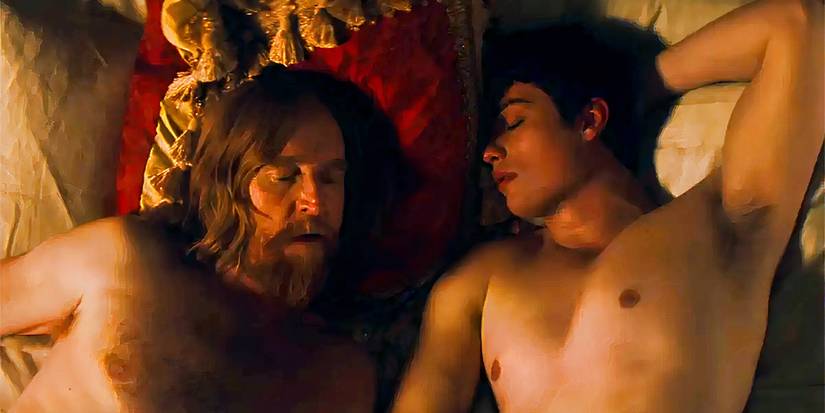 Two male characters from the series Mary and George asleep and lying in bed together.