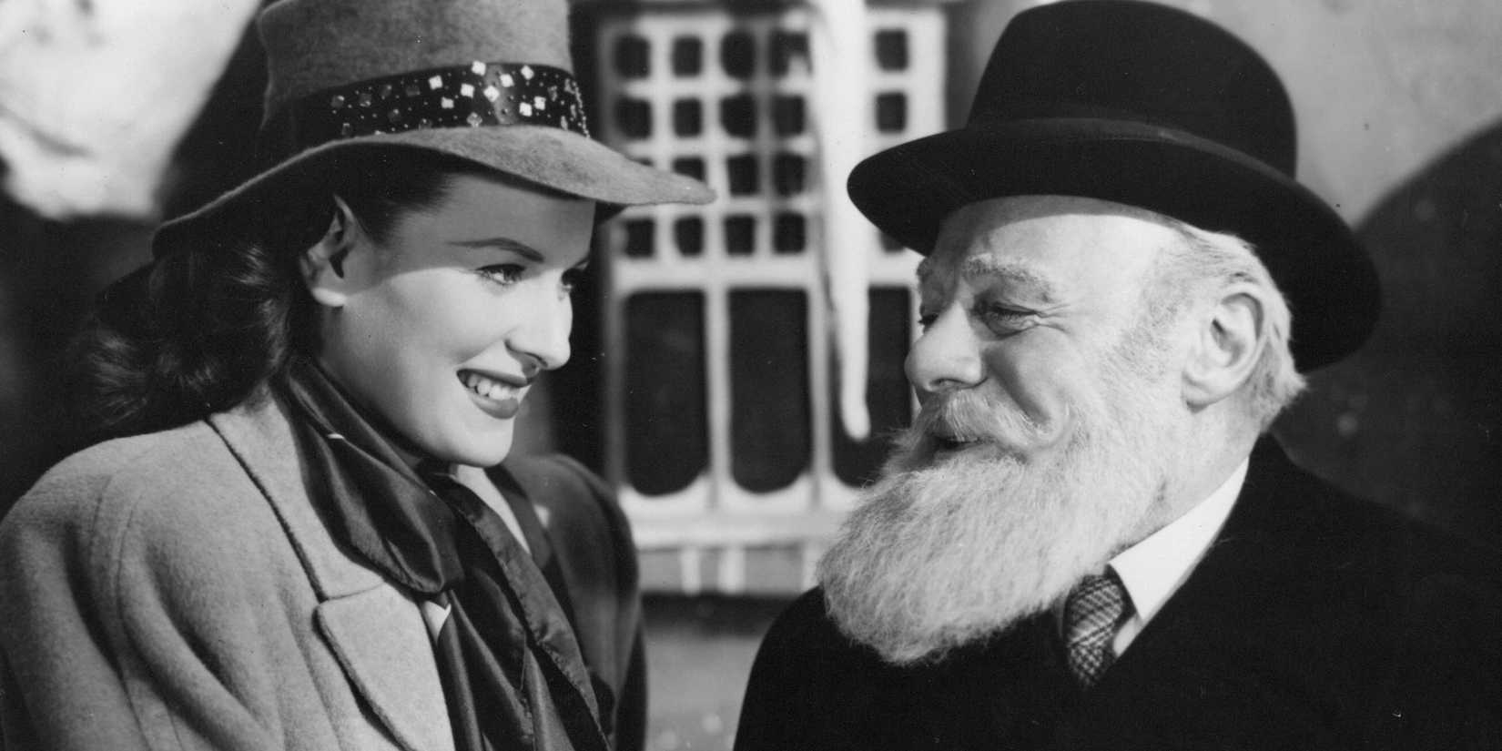 Maureen O'Hara as Doris talks and smiles with Edmund Gwenn as Kris Kringle in Miracle on 34th Street.
