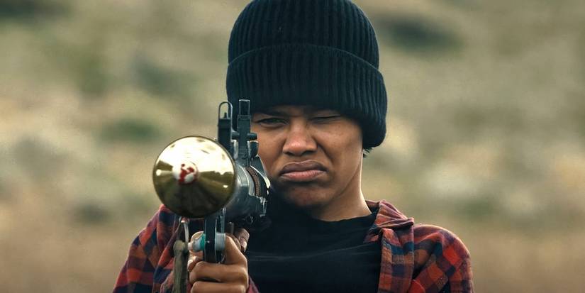 Teyana Taylor aiming a gun in One Battle After Another