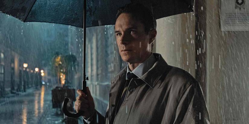 James D'Arcy as Henry standing under an umbrella in the rain in NCIS: Tony & Ziva.