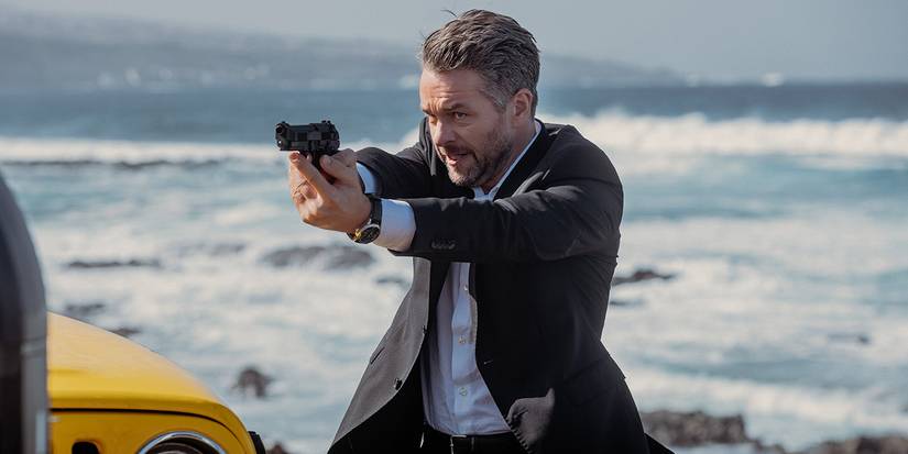 Julian Ovenden as Jonah holding a gun in NCIS: Tony & Ziva