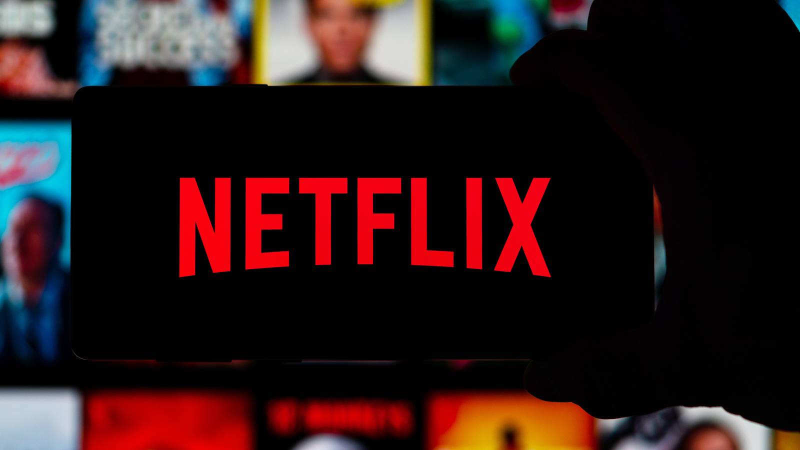 Image of someone holding a phone with the Netflix logo.