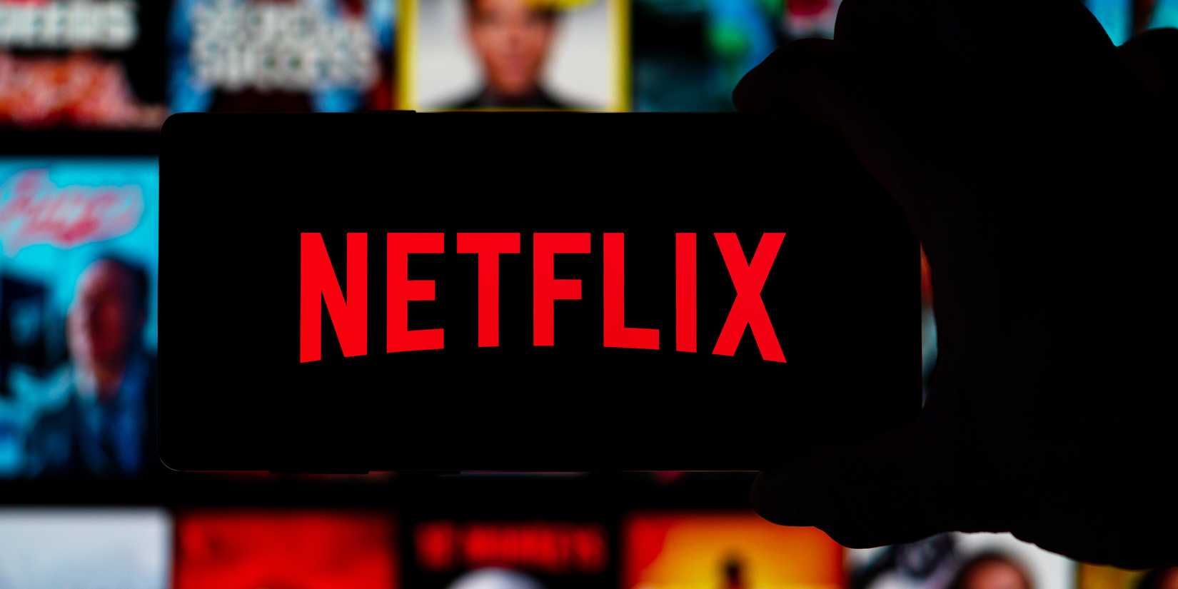 Image of someone holding a phone with the Netflix logo.