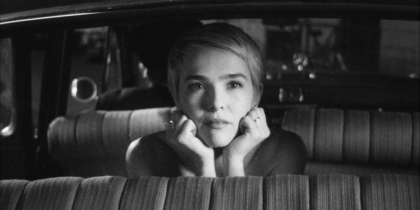 Jean Seberg in the backset of a car looking up dreamily.