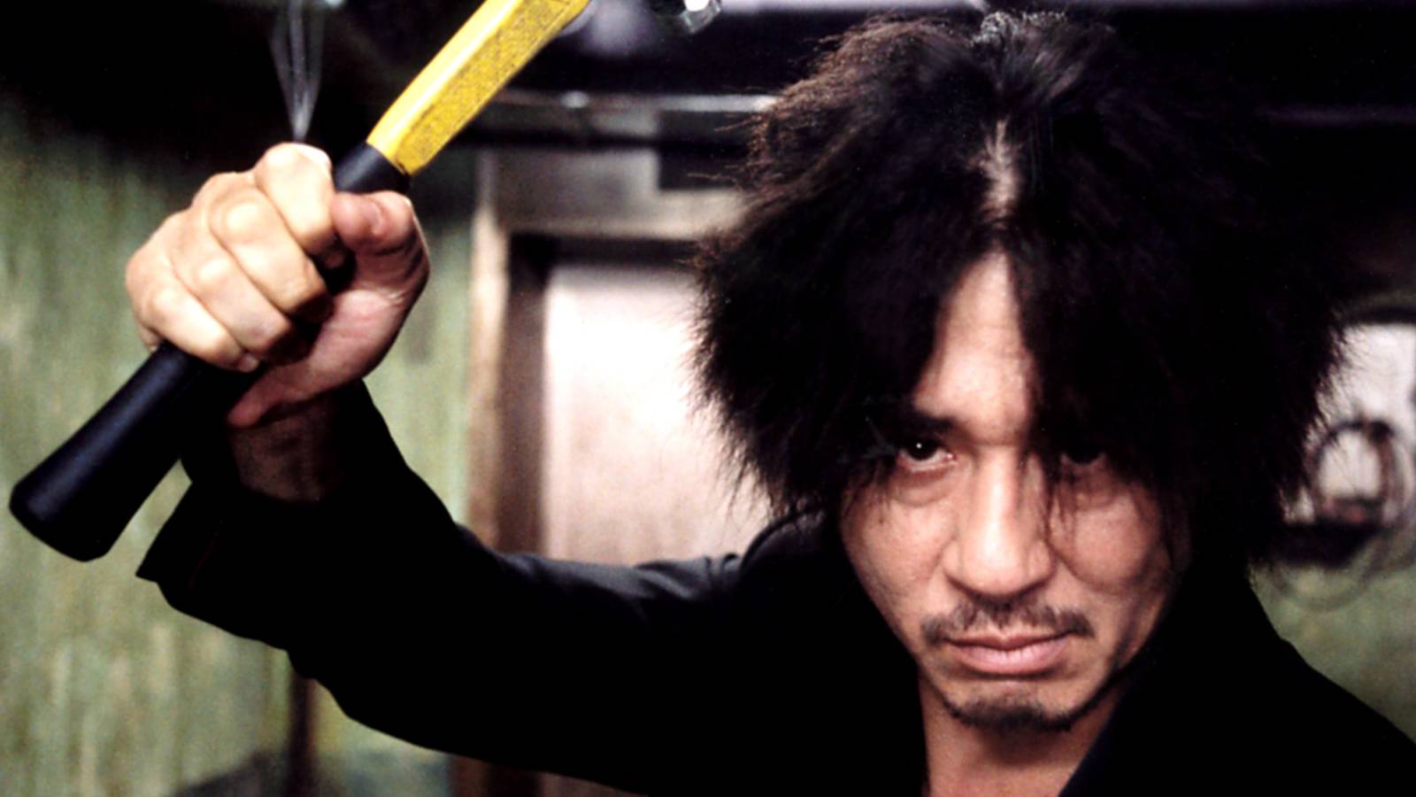 Oh Dae-su (Choi Min-sik) holding a hammer at the camera in Oldboy