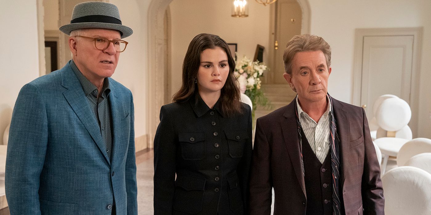 Charles, Mabel, and Oliver talking to someone in the hallway in Only Murders in the Building.
