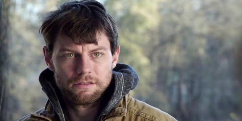 Kyle fica do lado de fora olhando para alguém fora da câmera em Outcast.