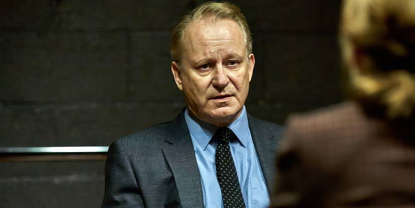 River (Stellan Skarsgård) sits across from someone in an interrogation room