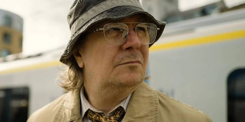 Gary Oldman as Jackson Lamb in a hat and glasses looking to the side in Slow Horses.