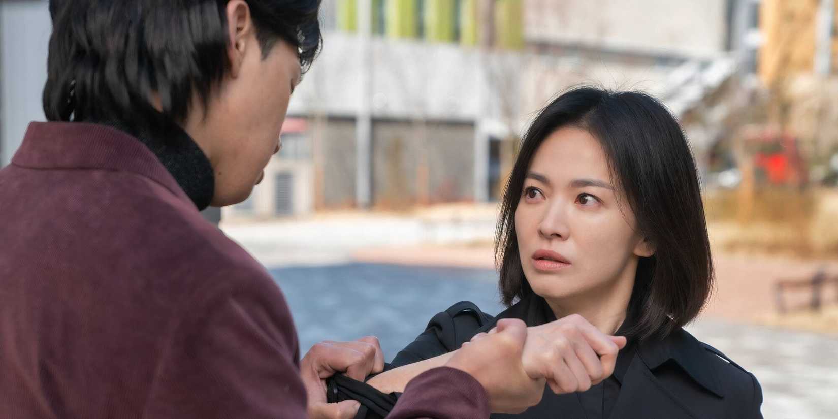 A man holds Song Hye-kyo's wrist in The Glory 