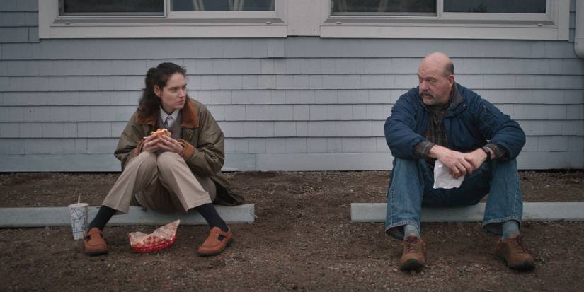 Eva Victor and John Carroll Lynch sitting and talking in Sorry Baby