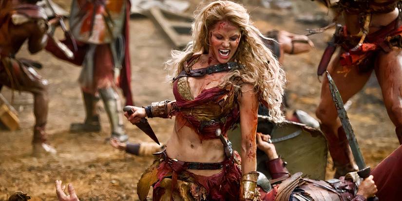 A model-like female gladiator viciously straddling a man and going in for the kill in the series Spartacus.