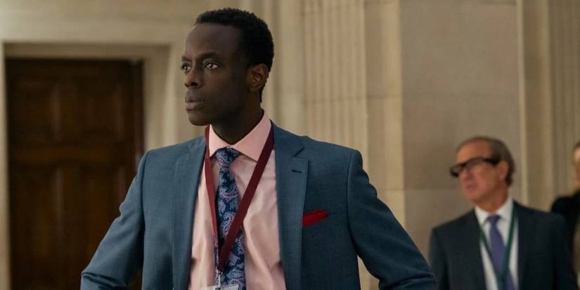 Stuart (Ato Essandoh) standing with his arms resting on his hips in The Diplomat.