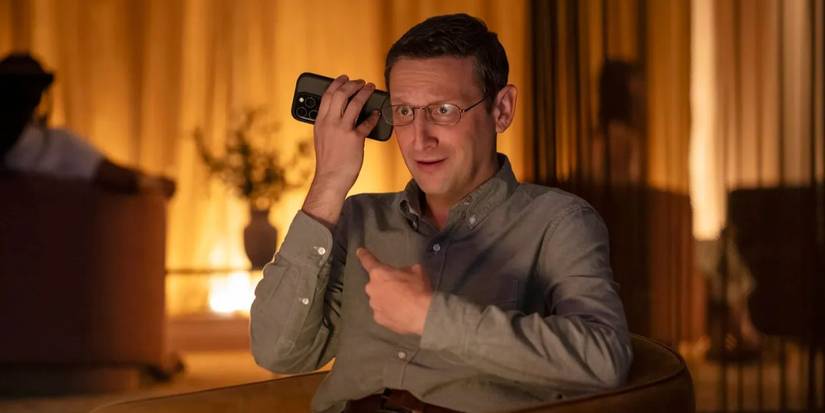 William Ronald Trosper (Tim Robinson) with his phone speaker next to his ear in 'The Chair Company'