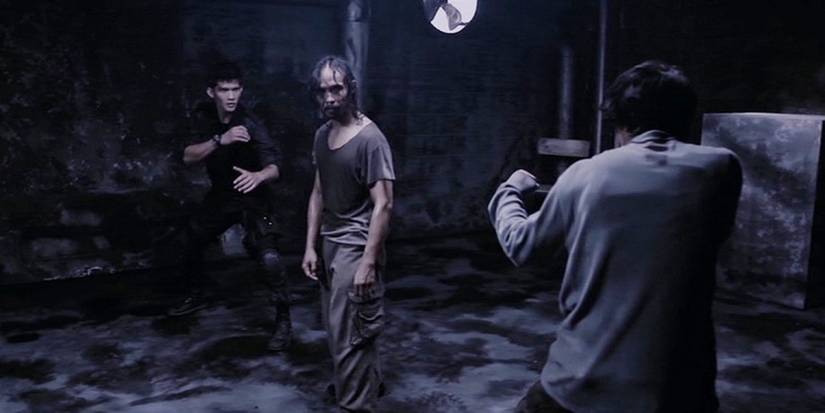 Two men pointing guns at a third man in The Raid - 2011