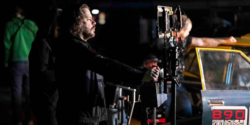 Edgar Wright standing behind a camera on the set of The Running Man.