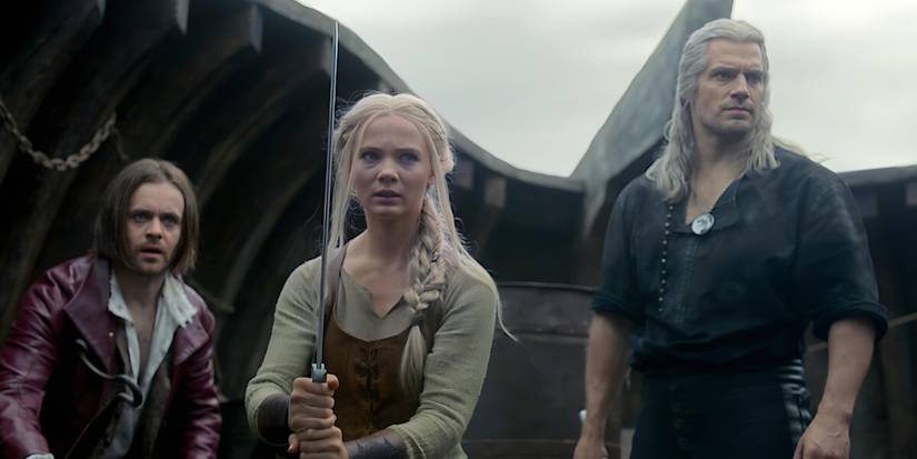 Ciri (Freya Allan) with a sword raised and Jaskier (Joey Batey) and Geralt (Henry Cavill) behind her in The Witcher Season 3