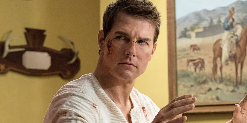 Tom Cruise in 'Jack Reacher' sitting, about to put his hands about his head