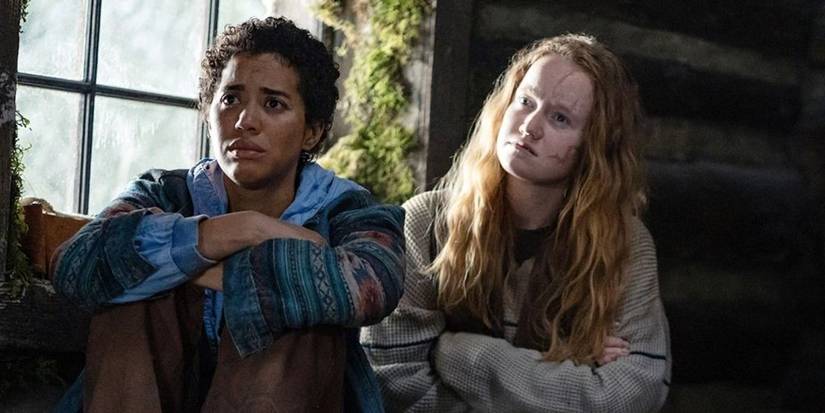 Young Van and Taissa sit near each other with arms folded and worried expressions in Yellowjackets.