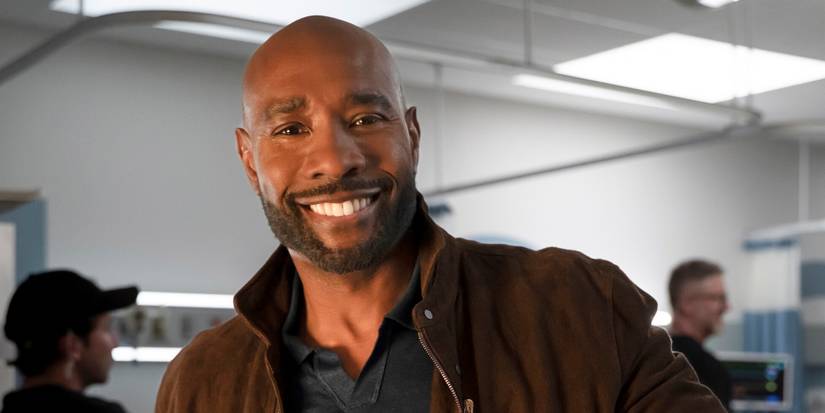 Morris Chestnut as John Watson with a big smile while standing in the hospital in Watson Season 2