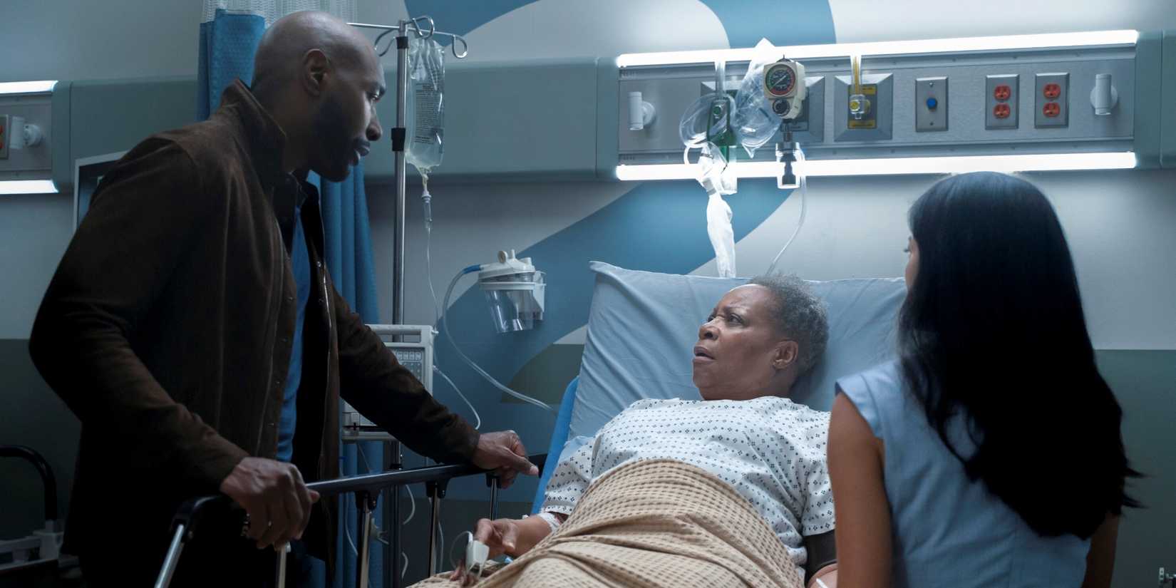 Morris Chestnut as John Watson with Rochelle Aytes as Mary at her mother's hospital bed in Watson