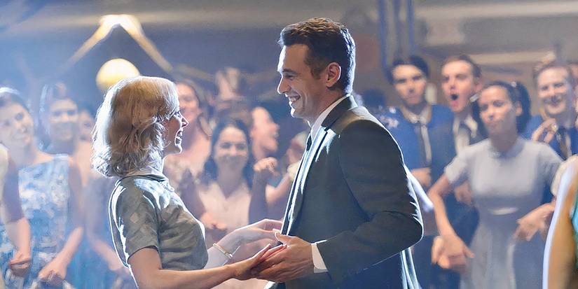 A man and woman dance with each other and smile as a crowd cheers in 11-22-63.