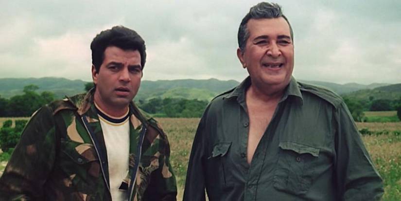 Dharmendra and a smiling man looking to the distance in Mera-gaon-mera-desh