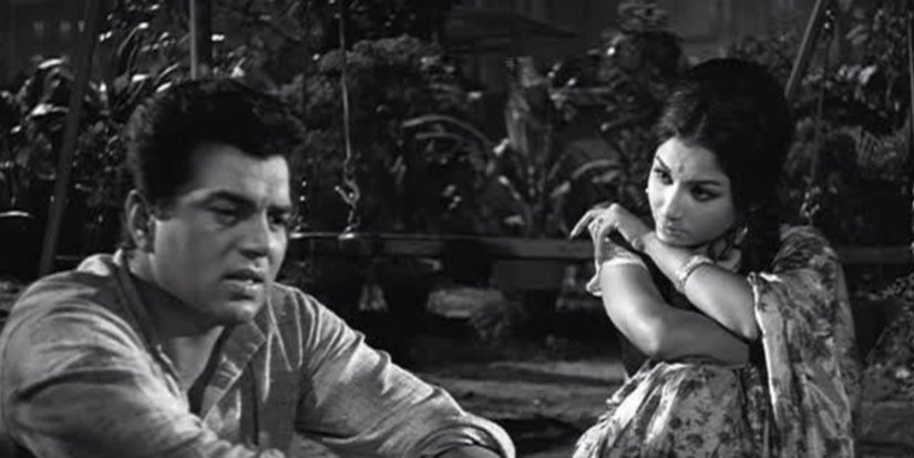 Dharmendra and a woman sitting down and talking in Anupama