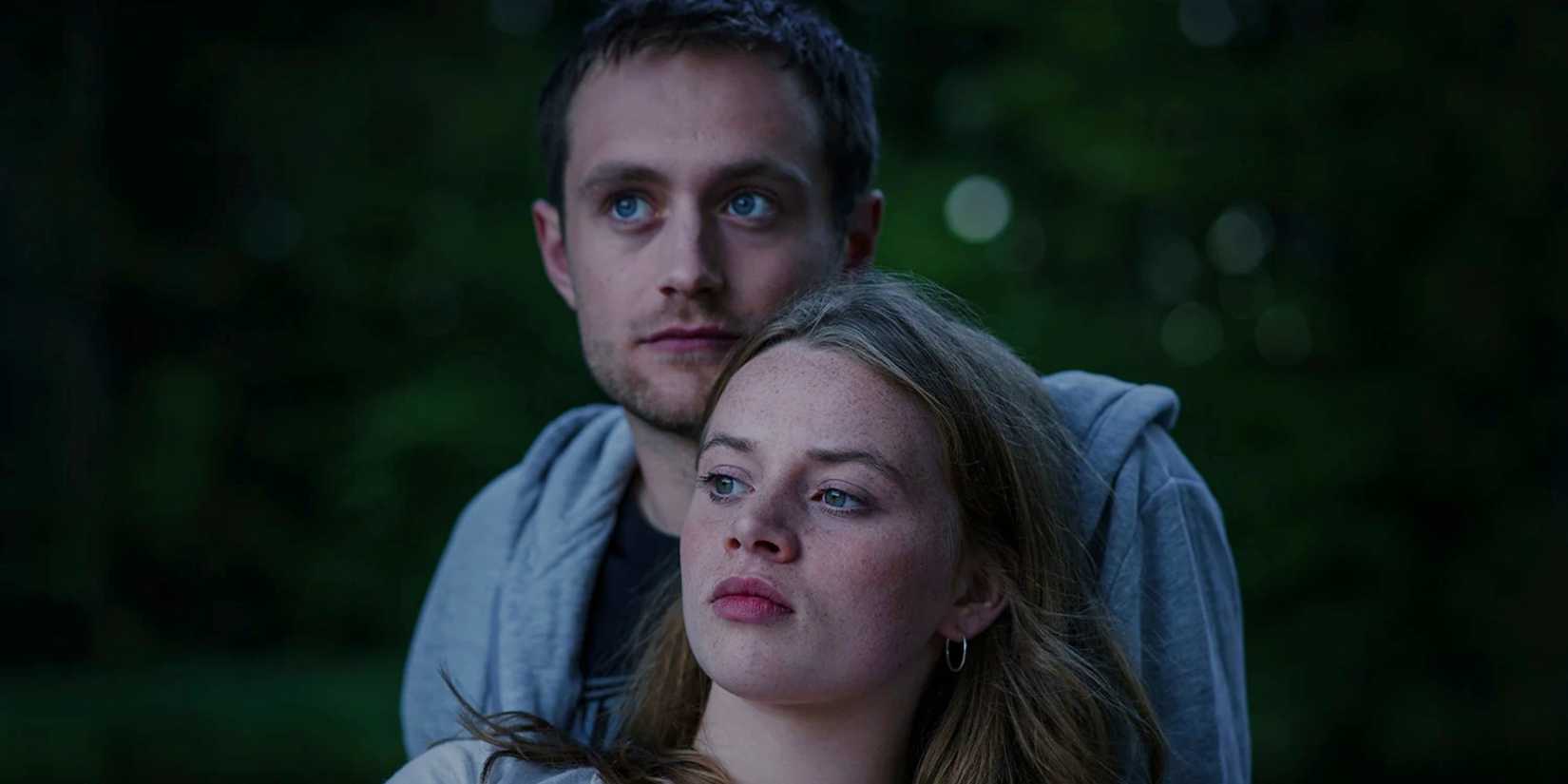 Mia sitting in Jasper's arms in Biohackers