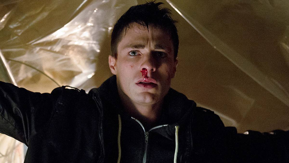 Colton Haynes with a bloody nose looking straight ahead and scared in Arrow