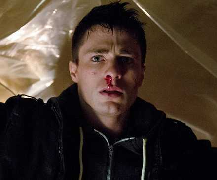 Colton Haynes with a bloody nose looking straight ahead and scared in Arrow