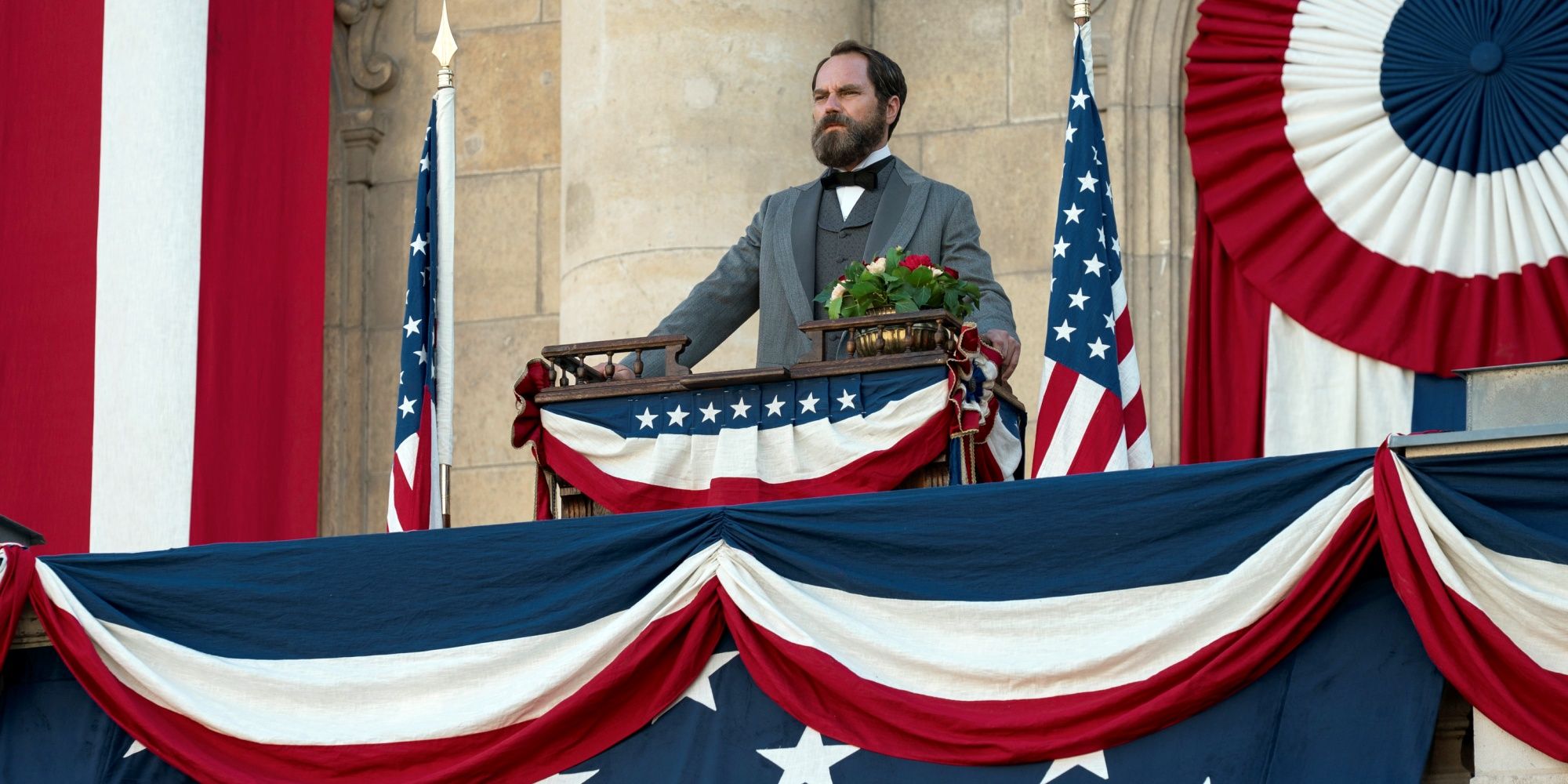 Michael Shannon as President James Garfield standing at a podium giving a speech in Death by Lightning 
