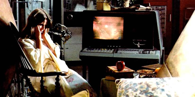 A woman covering her ears and looking down in Demon Seed