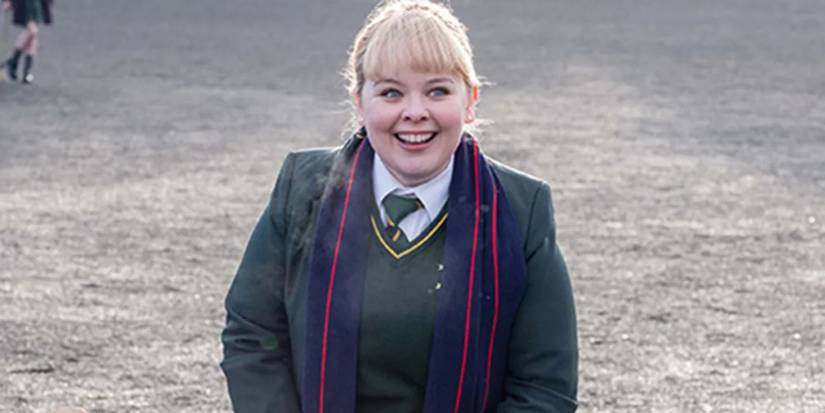 Nichola Coughlin as Claire smiling in a school uniform in Derry Girls.