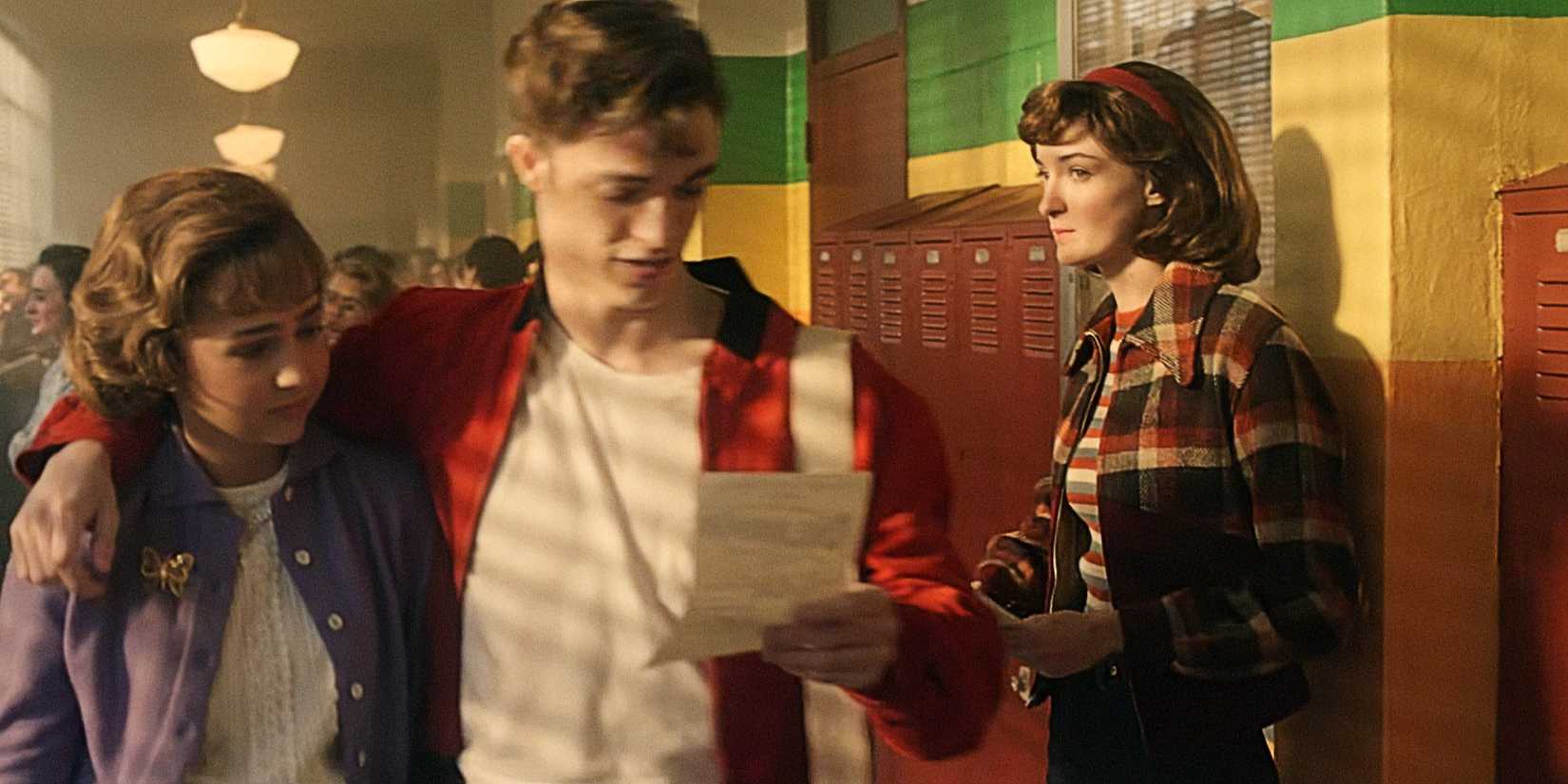 A young Joyce Maldonado (Byers) standing by a locker as a couple passes in Stranger Things Season 5