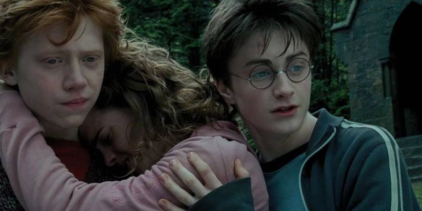 Hermione hugs Ron and cries while Harry stands close to them in Harry Potter and the Prisoner of Azkaban.