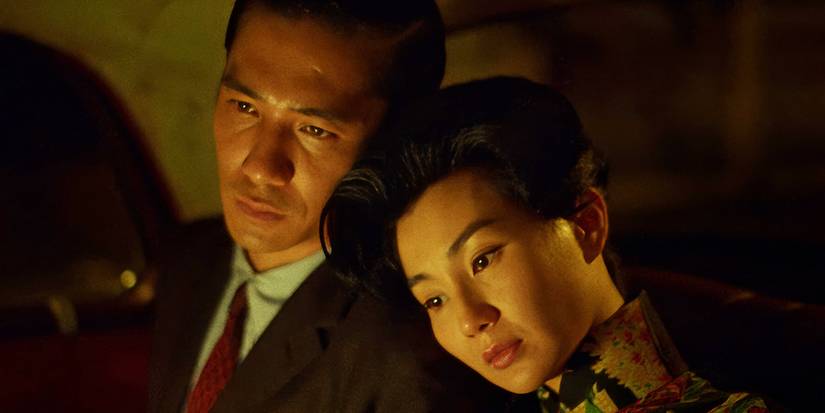 A woman resting her head in a man's shoulder in the back of a car in In the Mood for Love