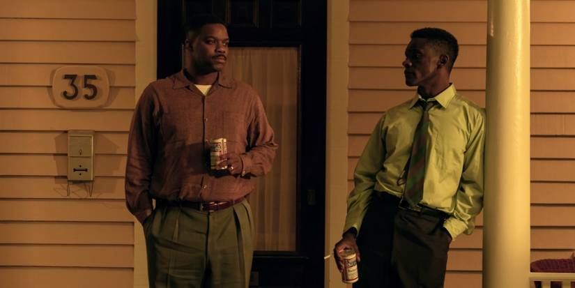Jovan Adepo as Leroy Hanlon standing on the porch with Chris Chalk as Dick Hallorann in IT: Welcome to Derry