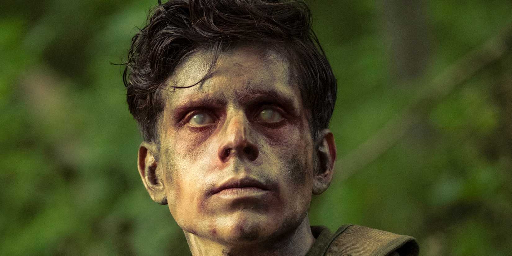 Rudy Mancuso as Captain Pauly Russo standing in the woods with cloudy eyes in IT: Welcome to Derry
